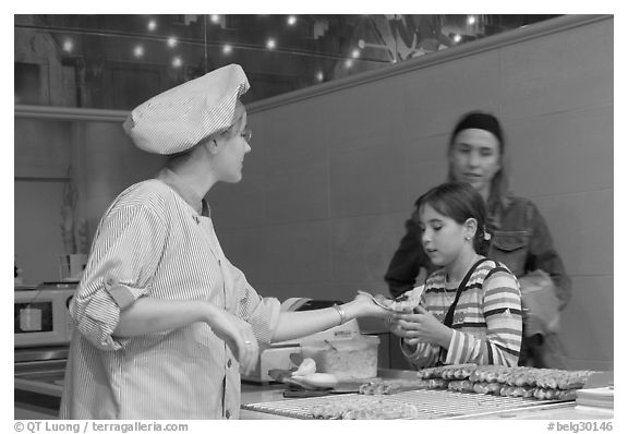 Vendor handing out a waffle. Brussels, Belgium (black and white)