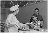 Vendor handing out a waffle. Brussels, Belgium (black and white)