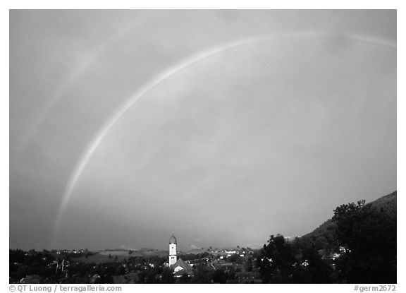 Rainbow over Nesselwang and St Andreas church. Bavaria, Germany