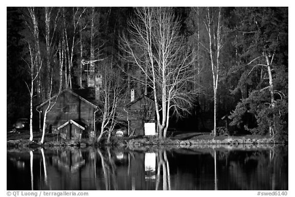 Wooden house reflected in a lake at sunset. Central Sweden