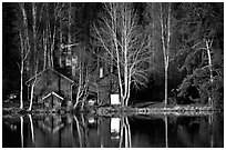 Wooden house reflected in a lake at sunset. Central Sweden (black and white)