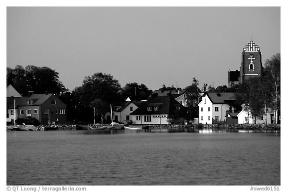 Houses, church, across the lake at dusk, Vadstena. Gotaland, Sweden