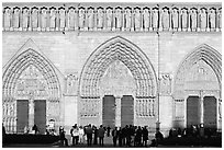 People and facade and gates of Notre Dame Cathedral, late afternoon. Paris, France ( black and white)