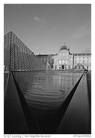 Pyramid and triangular basin in the Louvre, sunset. Paris, France