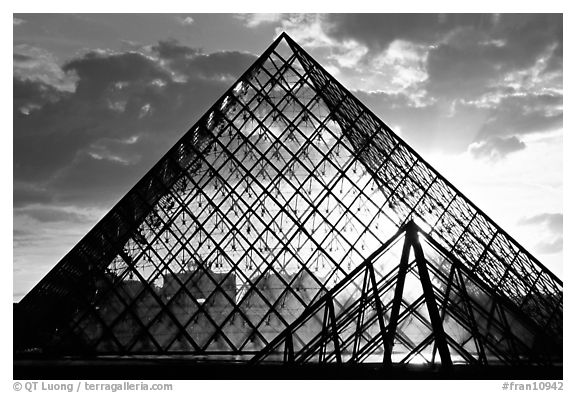 Sunset and clouds seen through Pyramid, the Louvre. Paris, France