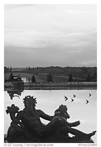 Sculptures, basin, and gardens at dusk, Versailles Palace. France