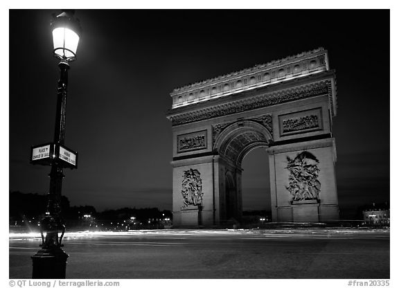 Street lamp and Etoile triumphal arch at night. Paris, France