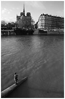 Fishing in the Seine river, Notre Dame Cathedral in the background. Paris, France ( black and white)