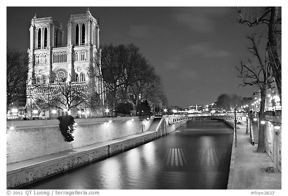 Facade of Notre Dame and Seine river at night. Paris, France