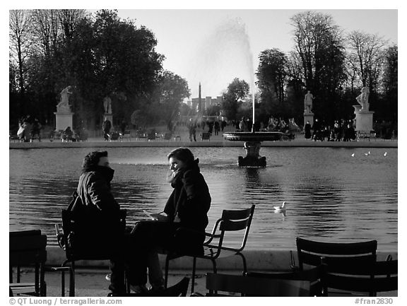 Couple sitting by basin in Tuileries Gardens. Paris, France