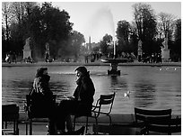 Couple sitting by basin in Tuileries Gardens. Paris, France ( black and white)