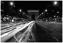 Arc de Triomphe seen from the middle of Champs Elysees at night. Paris, France (black and white)