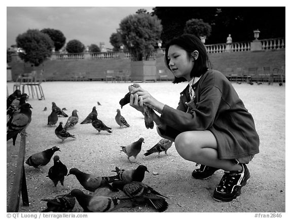 Girl feeding pigeon, Jardin du Luxembourg. Quartier Latin, Paris, France (black and white)