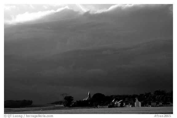 Stormy skies and village. France