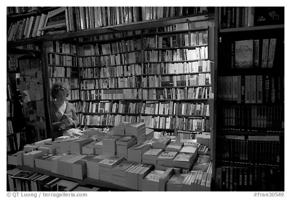 Checking a book in Shakespeare and Company bookstore. Quartier Latin, Paris, France (black and white)