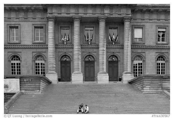 Two tourists sitting on the stairs of the Palais de Justice. Paris, France