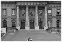 Two visitors sitting on the stairs of the Palais de Justice. Paris, France ( black and white)