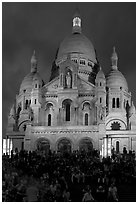 Visitors sitting on the stairs of the Sacre coeur basilic in Montmartre at night. Paris, France ( black and white)