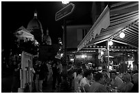 Outdoor dining at night on the Place du Tertre, Montmartre. Paris, France (black and white)