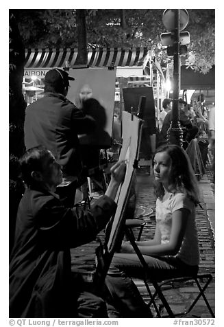 Artists drawing portraits at night on the Place du Tertre, Montmartre. Paris, France (black and white)