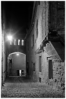 Cobblestone street by night inside medieval city. Carcassonne, France ( black and white)