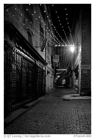 Lonely street by night with Tabac sign and Christmas lights. Carcassonne, France (black and white)