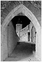 Ramparts and tower framed by gate at night. Carcassonne, France ( black and white)