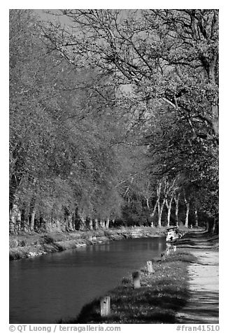 Walkway and boat along Canal du Midi. Carcassonne, France (black and white)