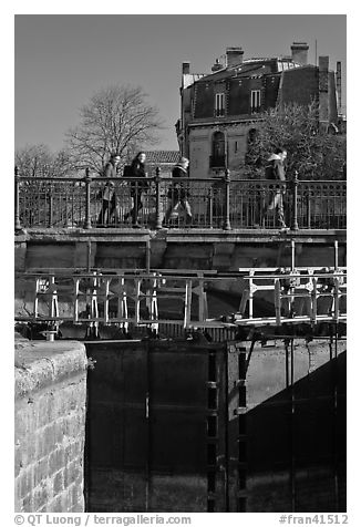 Pedestrians walking on brige above Canal du Midi. Carcassonne, France (black and white)