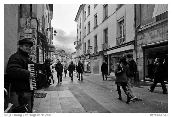 Accordeon musician on commercial pedestrian street. Grenoble, France (black and white)