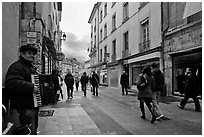 Accordeon musician on commercial pedestrian street. Grenoble, France (black and white)