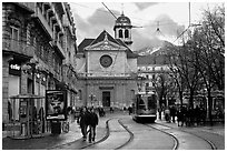 Street with people walking, tramway and church. Grenoble, France (black and white)