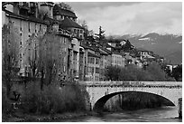 Stone bridge, houses, and snowy mountains. Grenoble, France (black and white)