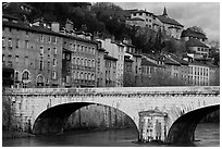 Stone bridge and brightly painted riverside townhouses. Grenoble, France (black and white)