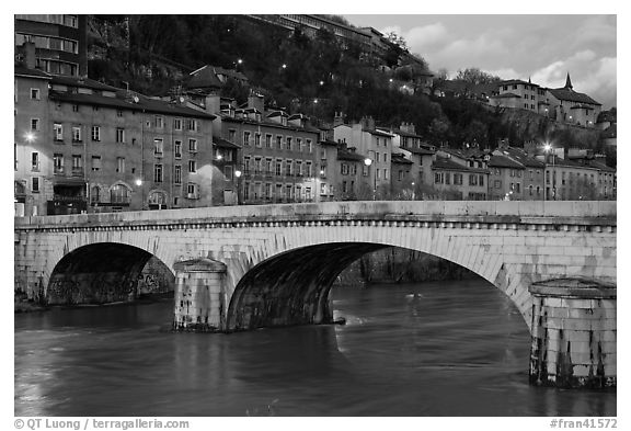 Bridge and brightly painted riverside houses at dusk. Grenoble, France