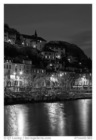 Hillside houses and Christmas lights reflected in Isere River. Grenoble, France (black and white)