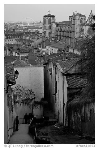 Stairs, rooftops, St-Jean Cathedral, and Ferris Wheel at dusk. Lyon, France (black and white)