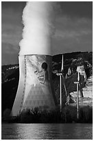 Cooling tower of nuclear power plant with ecology-themed art by Jean-Marie Pierret, and windmill. Provence, France (black and white)