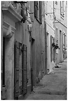 Painted facades in narrow street. Arles, Provence, France (black and white)