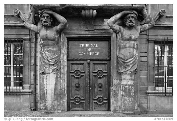 Wooden door framed by sculptures. Aix-en-Provence, France