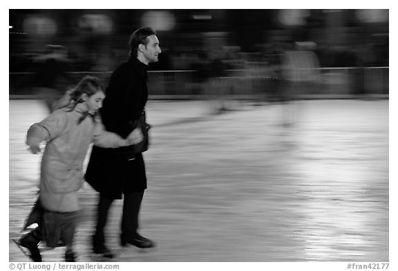 Man skating with daughter by night. Paris, France (black and white)