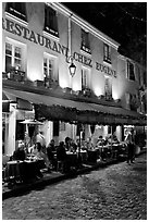 Restaurant with outdoor sitting by night, Montmartre. Paris, France (black and white)