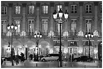 Lights and palace-like classical fronts of Hotel Ritz by Jules Hardouin-Mansart. Paris, France (black and white)