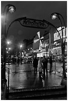 Art deco subway entrance and Moulin Rouge by night. Paris, France (black and white)