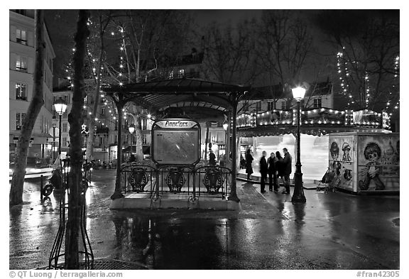 Square with subway entrance and carousel by night. Paris, France (black and white)