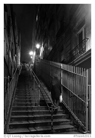 Woman climbing steep steps to the Butte, Montmartre. Paris, France (black and white)