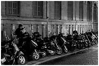 Scooters parked on a sidewalk at night. Paris, France (black and white)