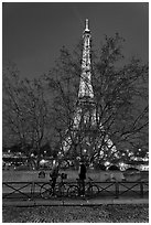 Bicyclists and Eiffel tower at night. Paris, France (black and white)