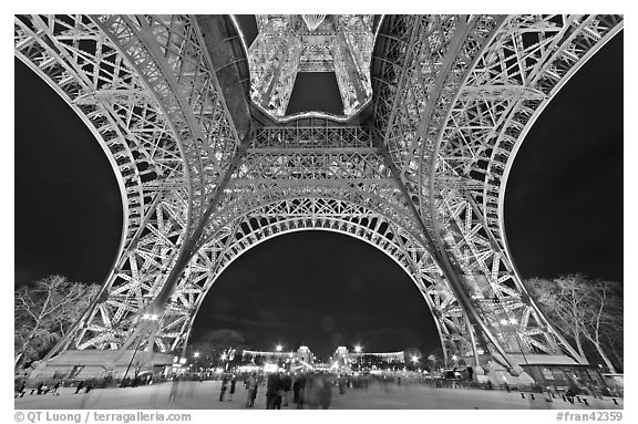 Eiffel Tower pilars from below and Ecole Militaire at night. Paris, France (black and white)