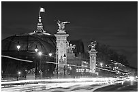 Petit Palais and trafic across Alexandre III bridge by night. Paris, France (black and white)